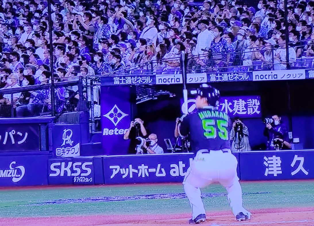 しゃがんで行方を見る村上と観客